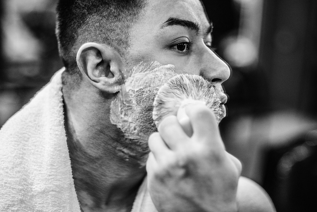 man using shaving brush in monochrome shot