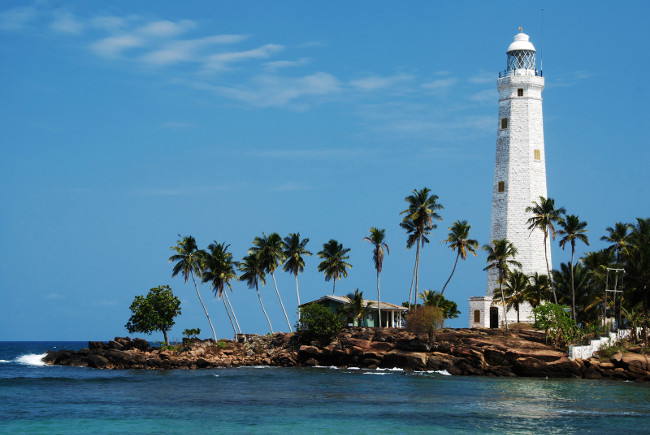 Beautiful white lighthouse Dondra Head, the southest cape of Sri Lanka - seen from the beach. The lighthouse is also a highest (161 feet) not only on the island but also in the whole Asia
