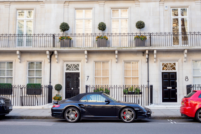 LONDON UK - April 14: Luxury black Porsche. Houses in London english architecture