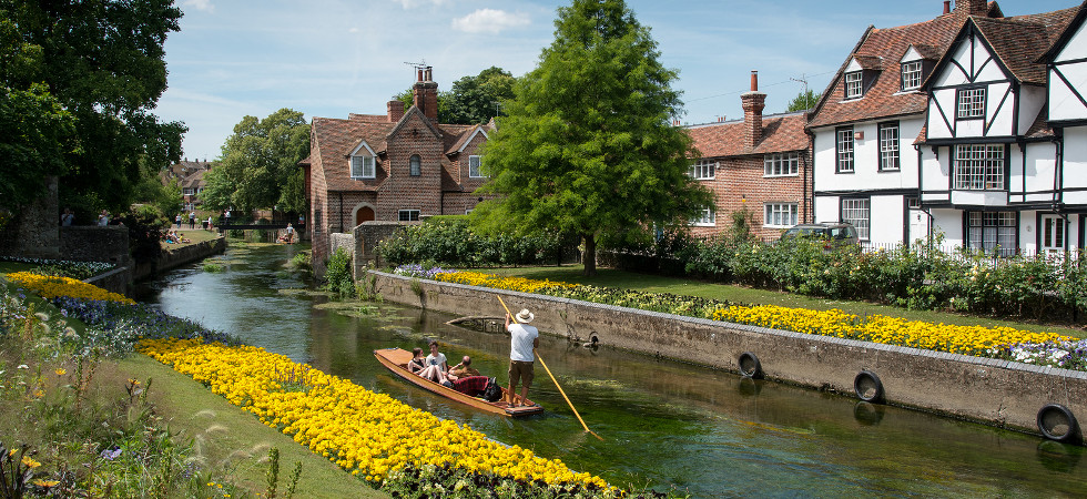 Canterbury Kent United Kingdom - 7 July 2017:Tourist people taking a romantic boat ride in the canal of the river stour at the beautiful Chartham gardens in the center of the city of Canterbury in Kent United Kingdom.