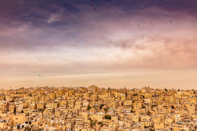 Amman, Jordan, view of the old city, a large complex of decaying buildings overlooking the citadel located on Jabal Al Qal'a. Kites in the sky.