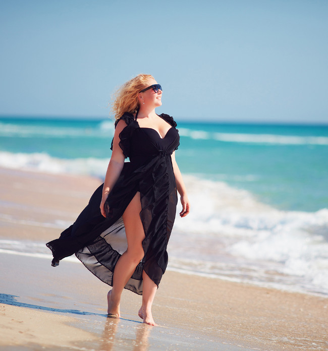 body positive plus size woman enjoys summer day at the beach