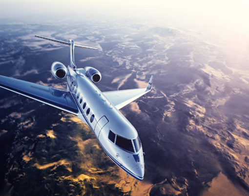 Realistic photo of silver generic design private Jet flying over the mountains. Empty blue sky with sun at background.Business Travel by modern Luxury Plane.Horizontal.Closeup photo. 3D rendering