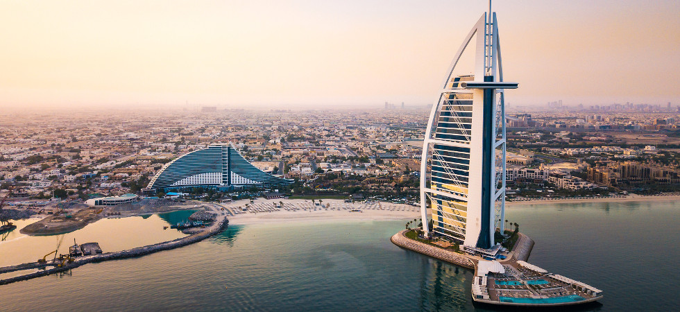 Dubai, United Arab Emirates - June 5, 2019: Dubai seaside skyline and Burj Al Arab luxury hotel aerial view at sunrise
