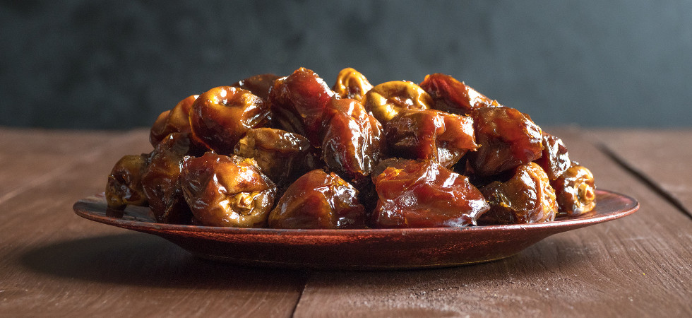 Delicious organic sweet dates in bowl with syrup. Iftar dates.