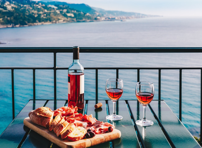 Two glasses of wine and italian snacks  with amazing view at sunset in Italy. Romantic dinner for two on panoramic terrace