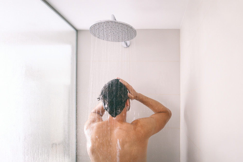 Man taking a shower washing hair
