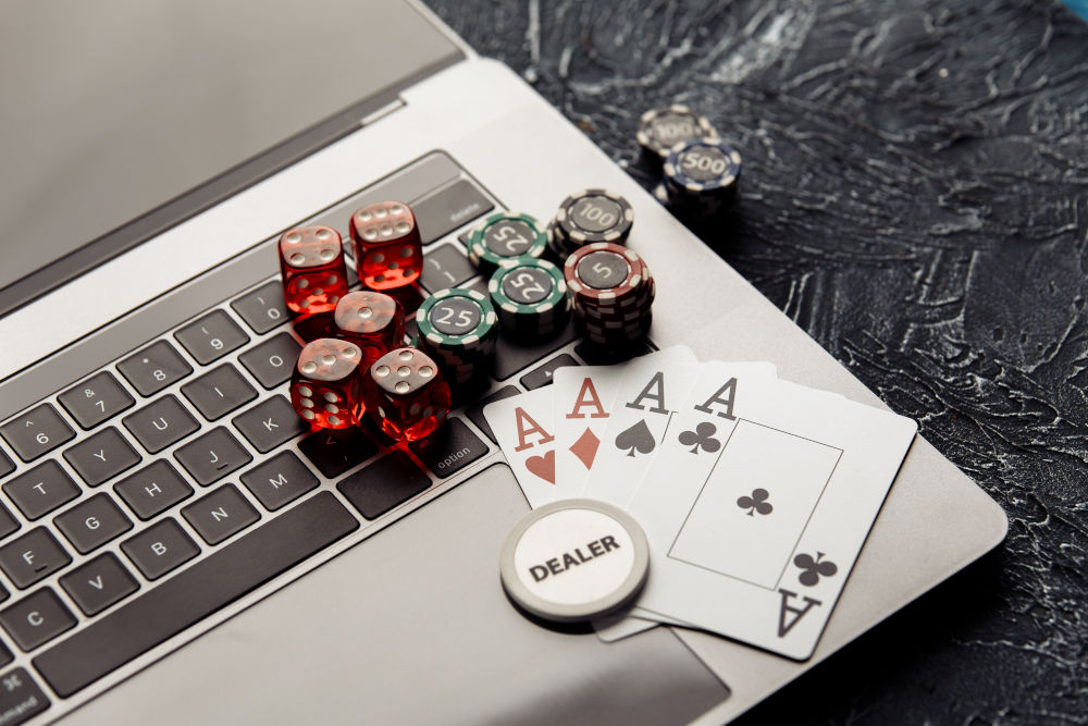 Chips, red dices and playing cards on laptop