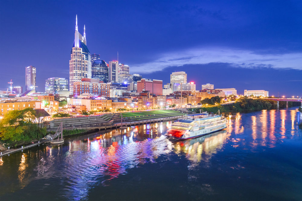 Nashville, Tennessee, USA skyline and riverboat on the Cumberland River at night.