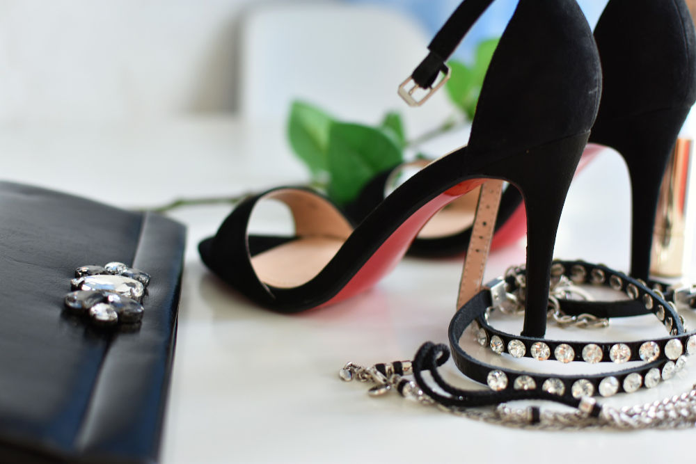 Pair of heels next to a belt and bag