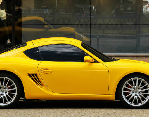 Yellow supercar Porsche Cayman s parked in the city