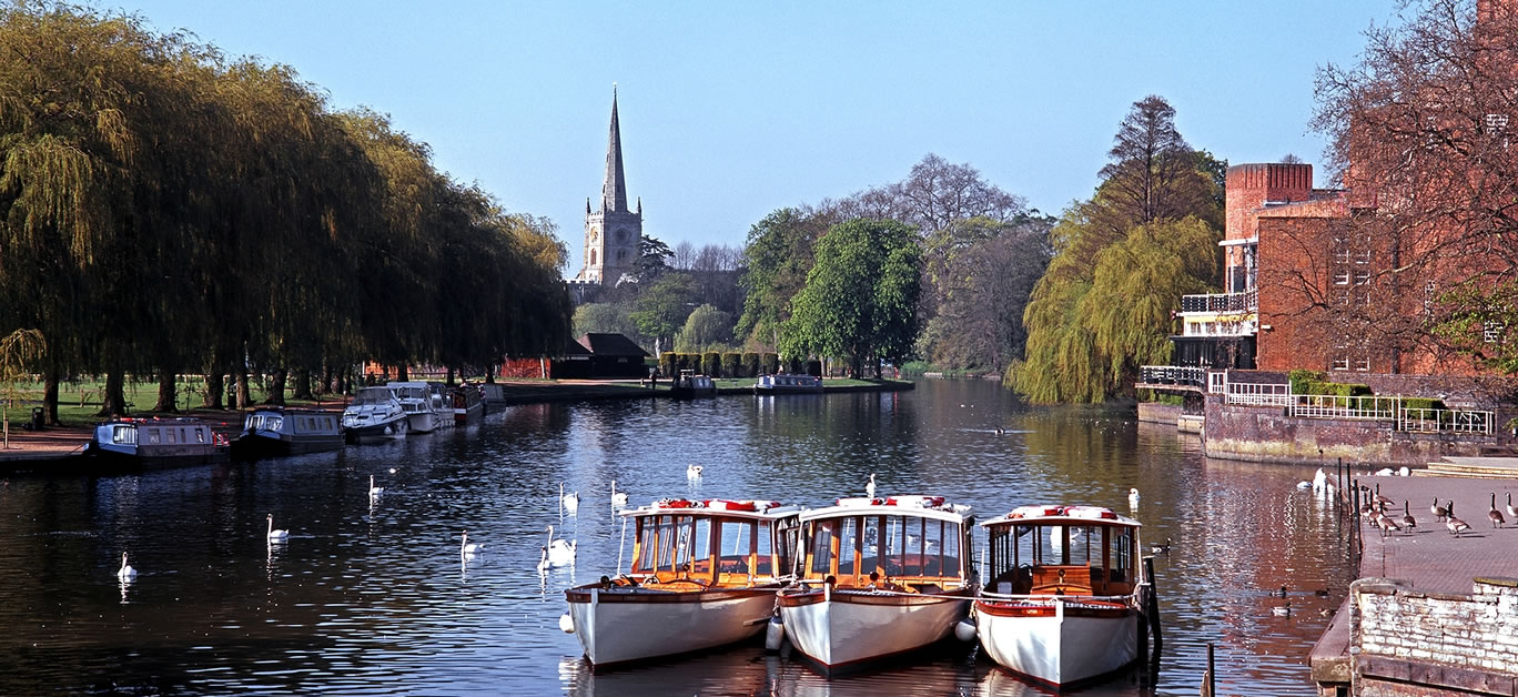 River Avon with pleasure boats moored and Church to rear Stratford-upon-Avon Warwickshire England UK Western Europe.