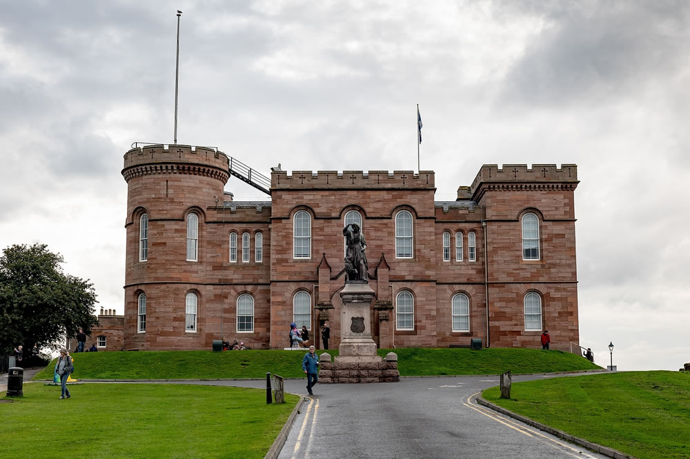 Inverness Castle with Floar MacDonald statue on a top of the hill in cloudy summer day