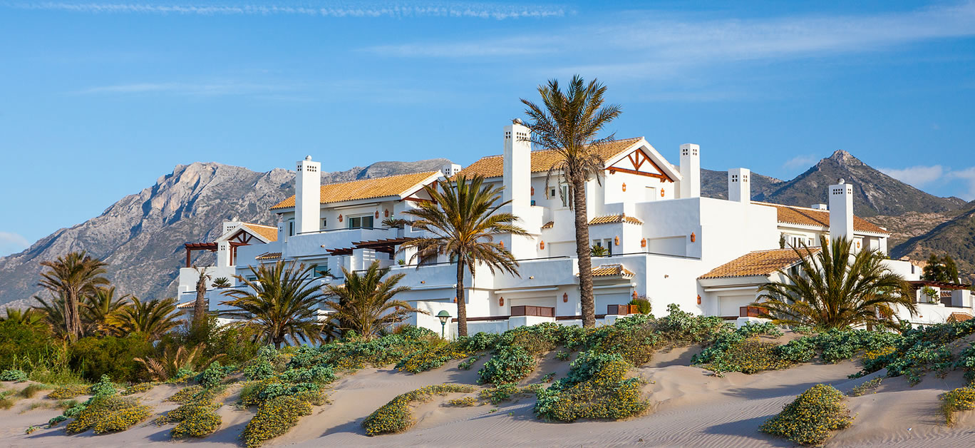 A luxury Apartment and Villa development on the beach i on the Costa del Sol near Marbella. Spain with beautiful deep blue sky and mountains in the background