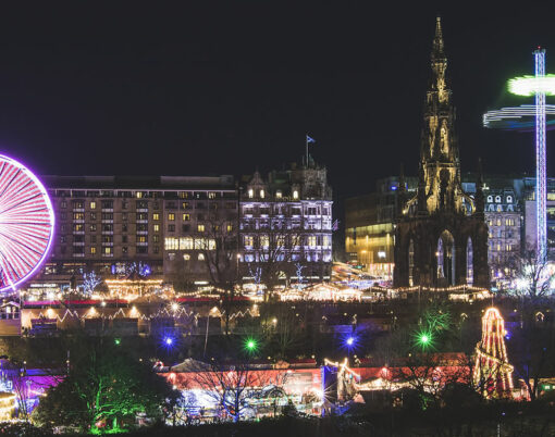 Christmas market in Edinburgh and Walter Scott Monument at night, Scotland