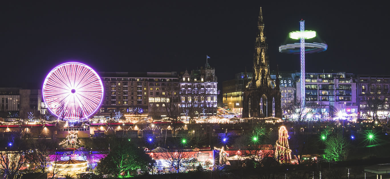 Christmas market in Edinburgh and Walter Scott Monument at night, Scotland