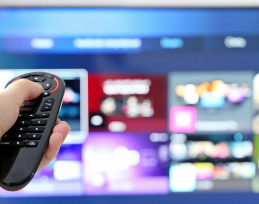 Female hand with remote controller on smart TV screen background