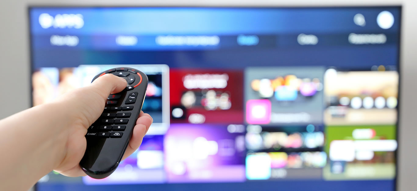 Female hand with remote controller on smart TV screen background
