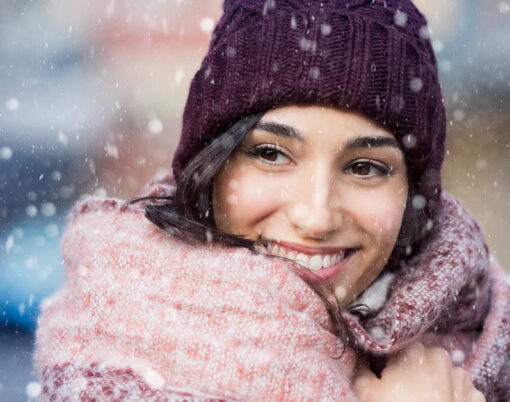 Smiling woman wearing wool bonnet and scarf in a winter cold day