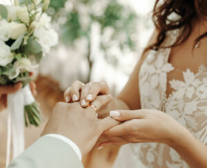 Hands of newlyweds with wedding rings and a wedding bouquetf