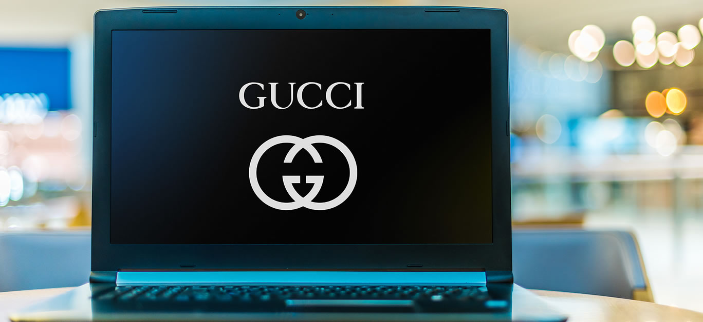 Laptop computer displaying logo of Gucci, an Italian luxury brand of fashion and leather goods