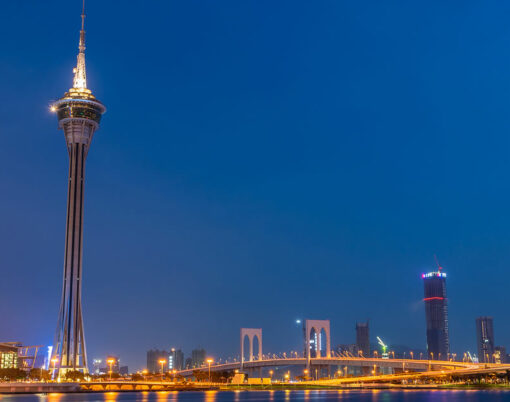 Night view of Macau Tower,famous traveling tower under blue sky near river in Macao, China.