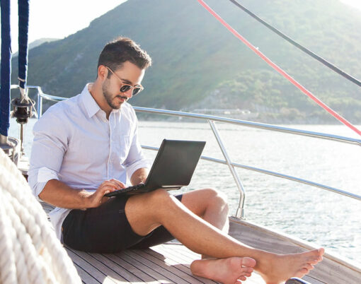 Man working on yacht office with laptop