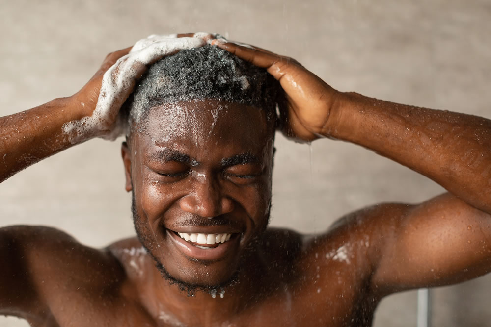 African Man Washing Head With Shampoo Taking Shower In Bathroom