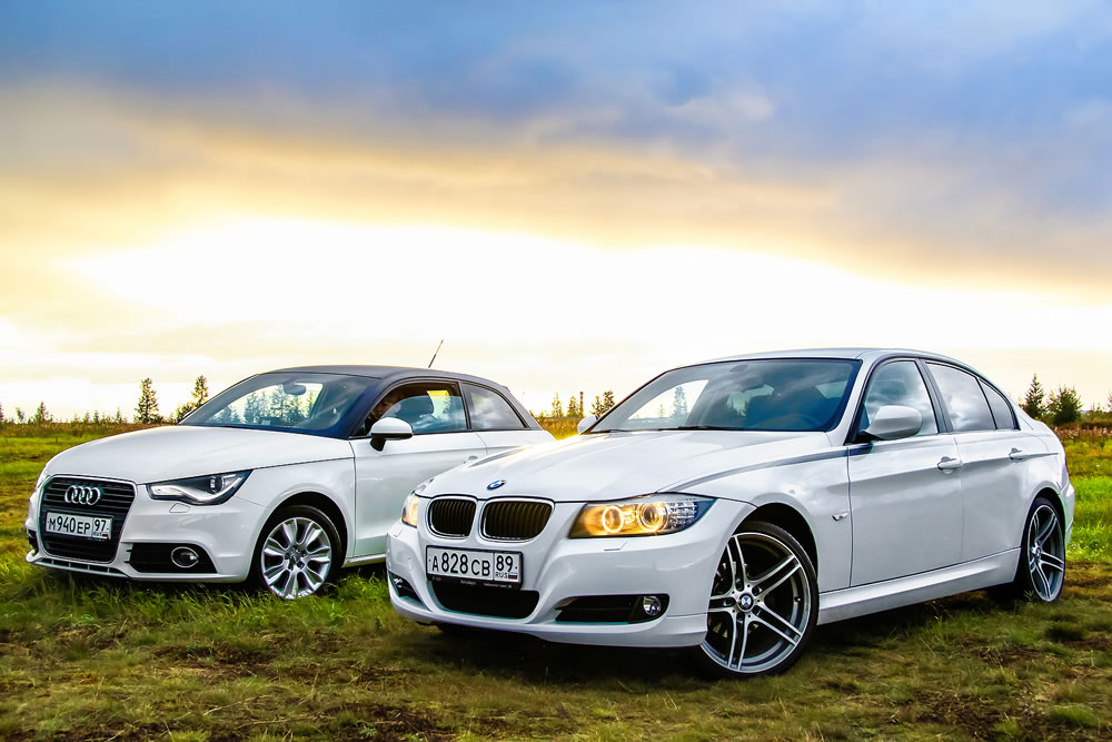 Motor cars Audi A1 and BMW E90 318i at the countryside.