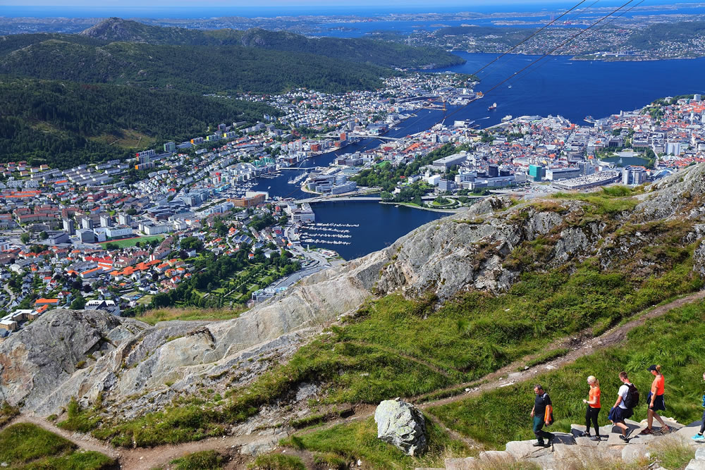 People hike Ulriken mountain trail overlooking city of Bergen, Norway.