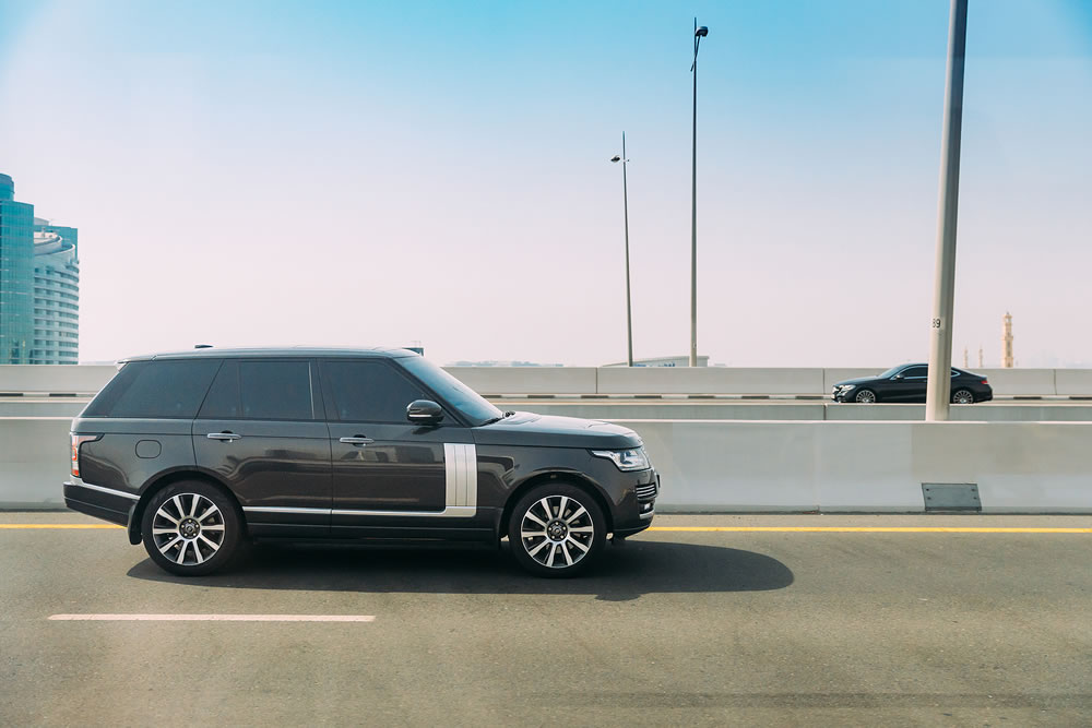 Black 2013 Range Rover Vogue car fast mooving on street in Dubai