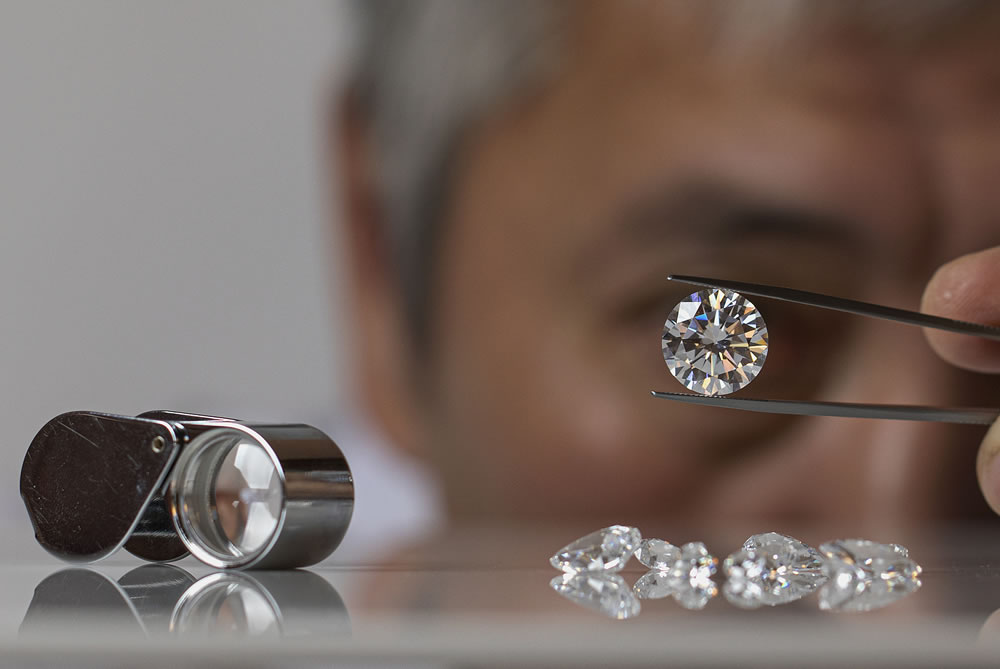 Jeweller man looking at round shape diamond