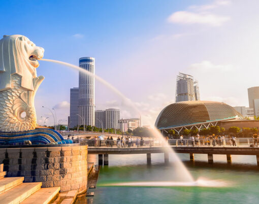 Merlion statue fountain in Merlion Park and Singapore city skyline at sunrise