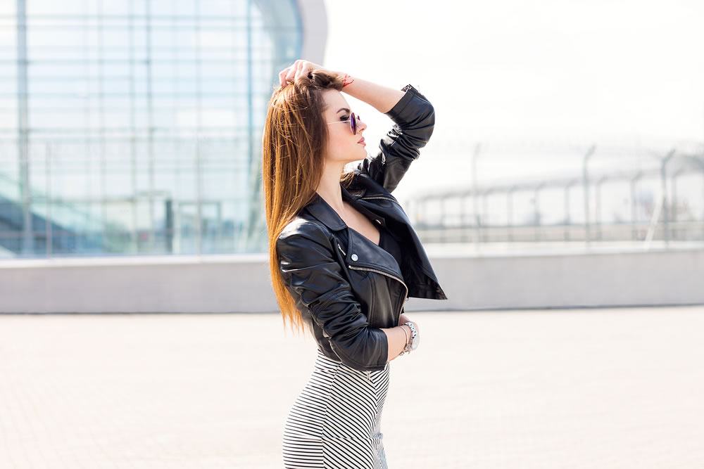 Girl model outdoor portrait wearing leather jacket and skirt