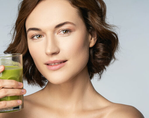 Beautiful young woman holding glass of smoothie