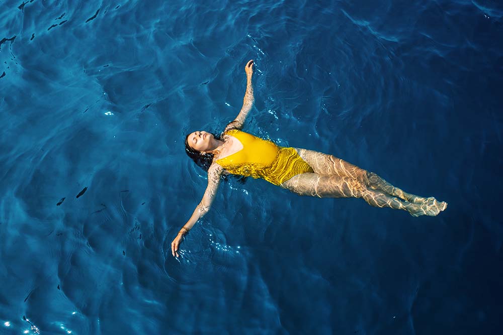 Woman in one-piece Yellow Swimsuit in the sea