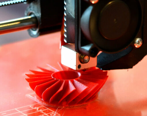 3D printer prints red shapes on a red background