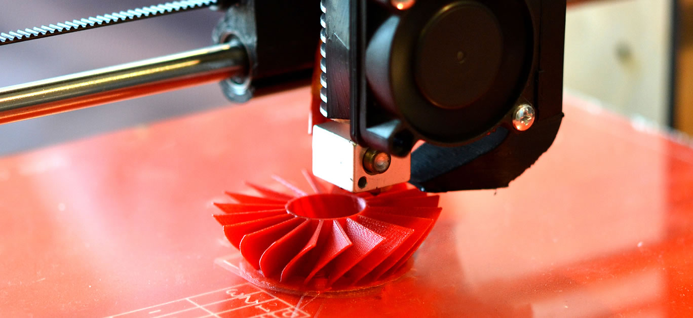 3D printer prints red shapes on a red background