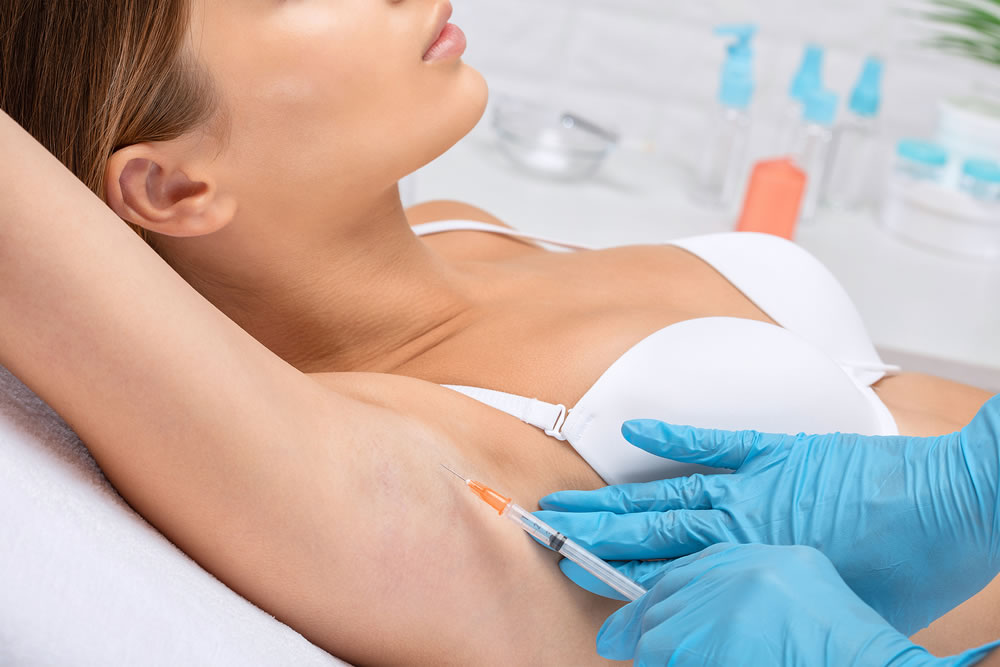 Aesthetic cosmetologist makes lipolytic injections to burn fat on the arm and body of a woman