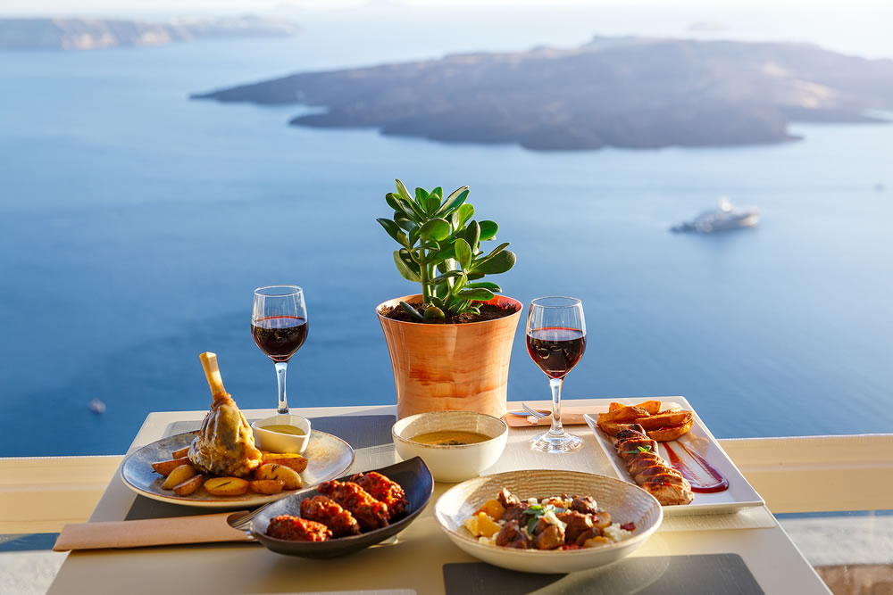 Dinner for two in a restaurant overlooking the sea and the island of Santorini, Greece