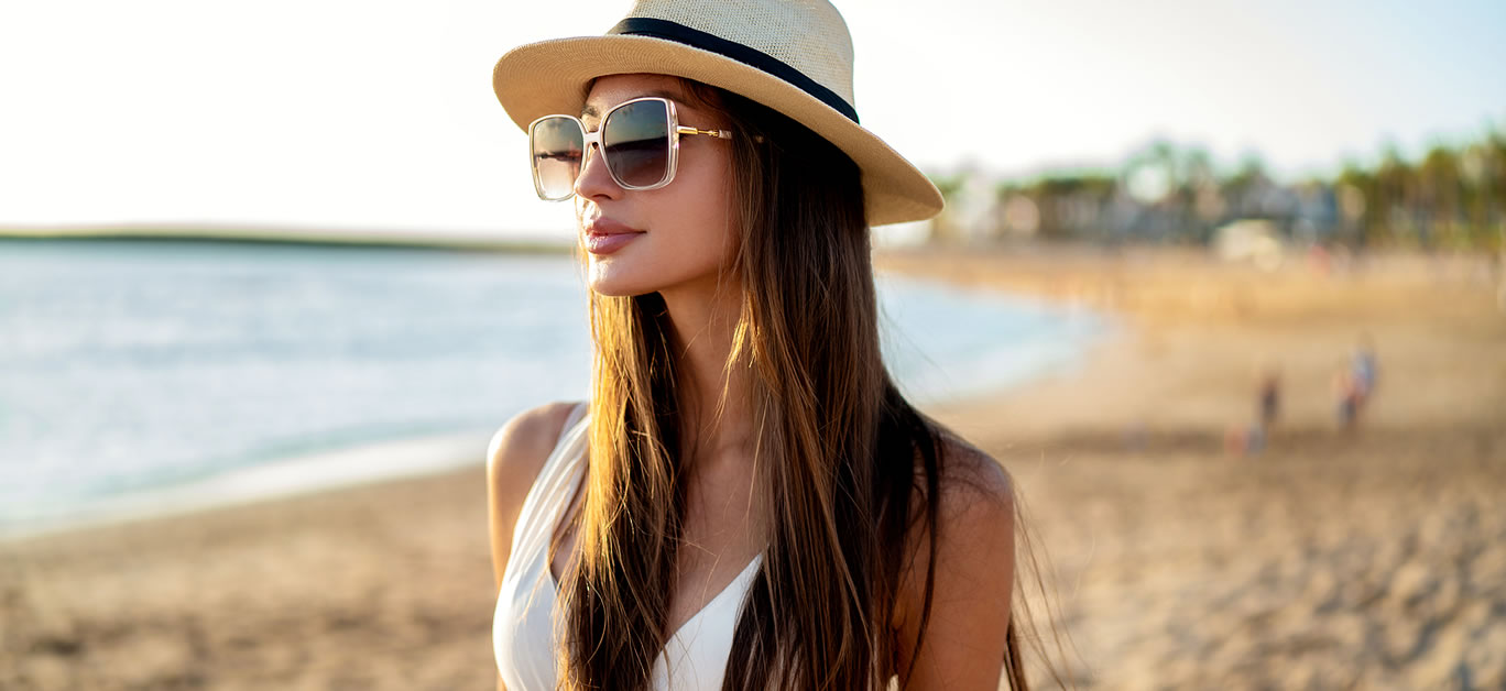 Young beautiful woman enjoying summer vacation, walking at the beach