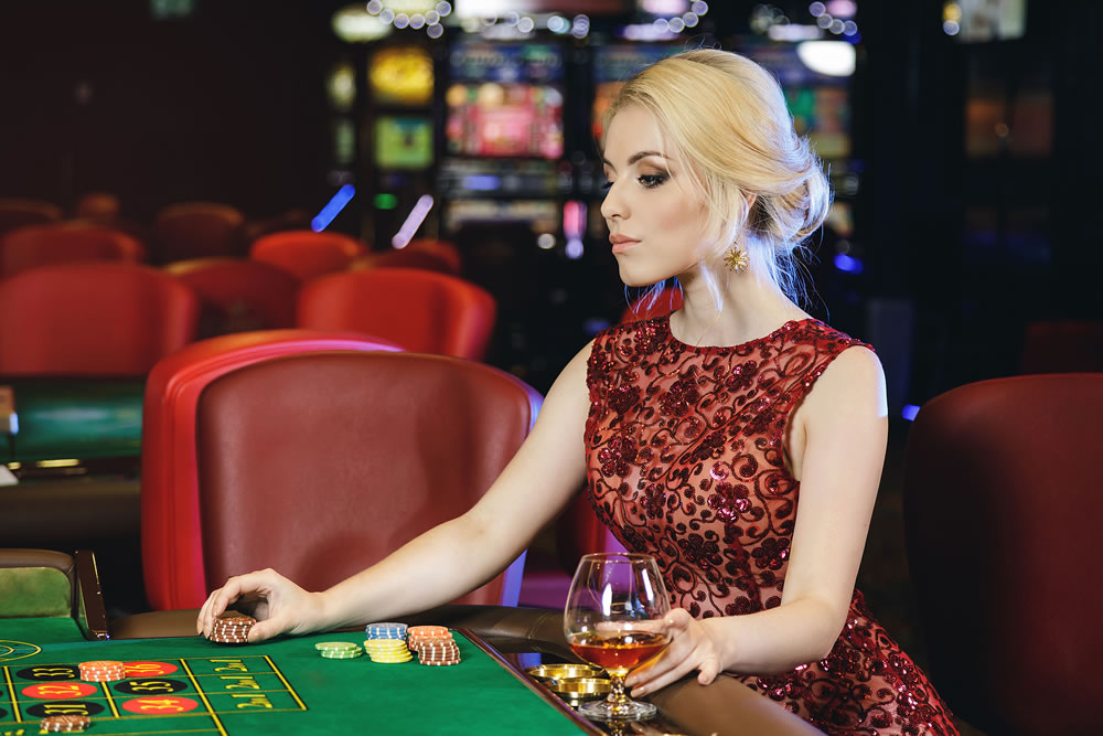 Young blonde woman playing roulette in the casino