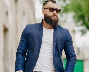 manly bearded man dressed stylishly stands on street