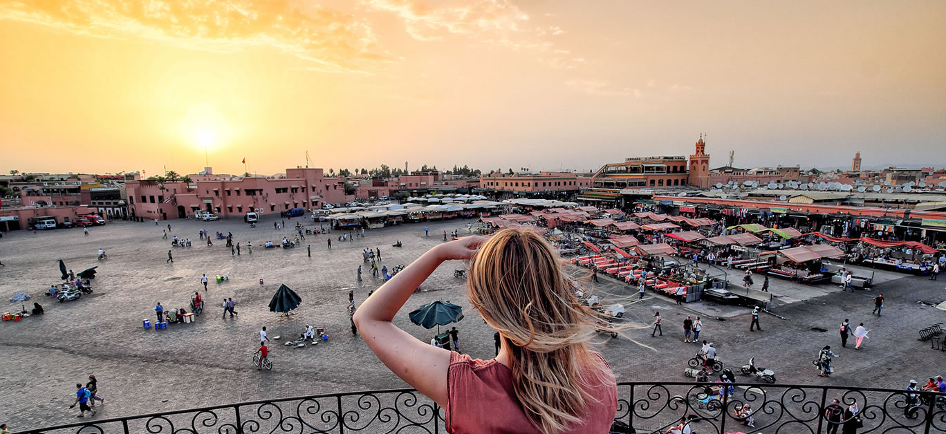 Jamaa el-Fna market Marrakech at sunset. Tourist watching the shops in the old medina.