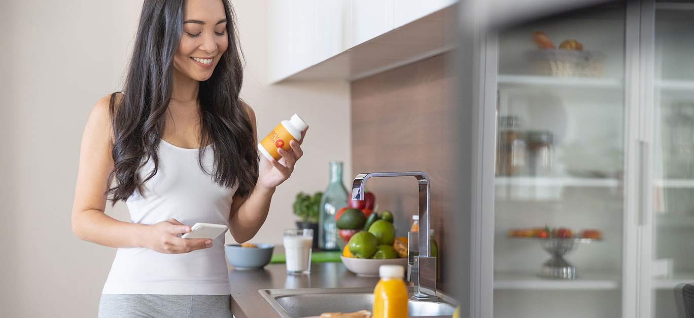 Woman with a dietary supplement in the kitchen