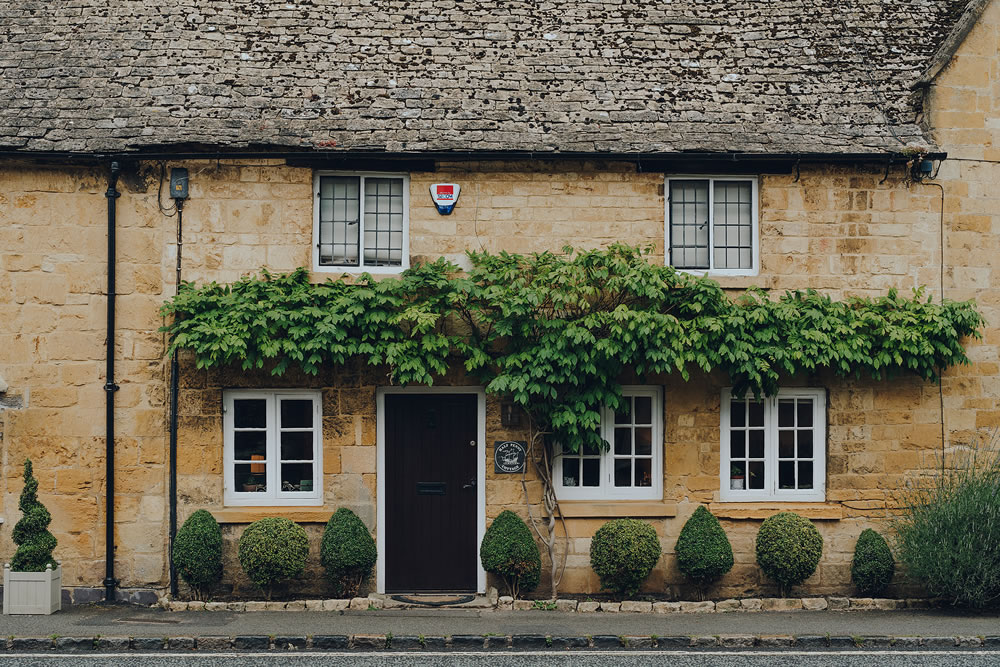 Facade of a traditional limestone house in Broadway, a large historic village within the Cotswolds in the county of Worcestershire, England.