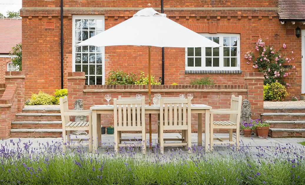 Large UK country house with garden furniture on a patio in a back garden