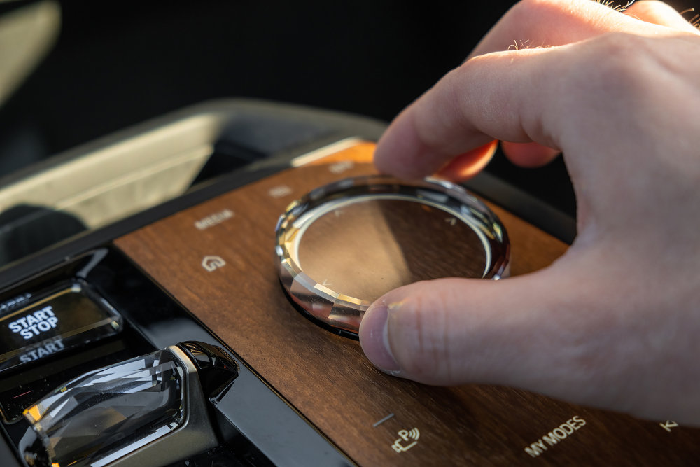 Man uses multimedia system control in luxury car BMW IX.