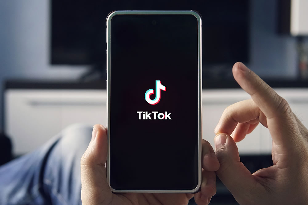 Men holding Phone with TikTok logo on the screen