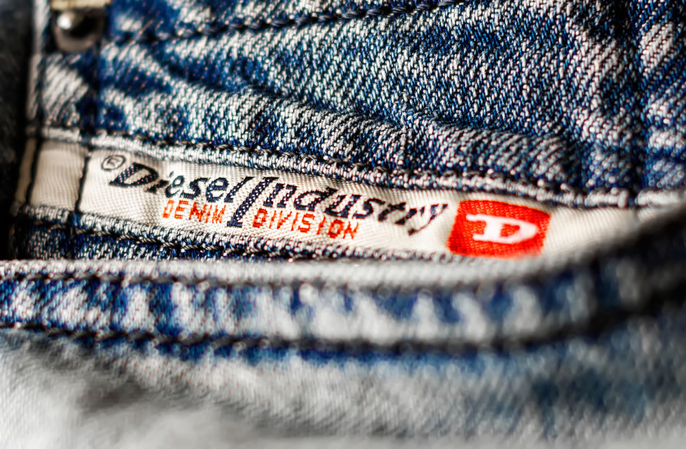 Detail of the Diesel Industry logo sewn on the front pocket of a pair of jeans trousers